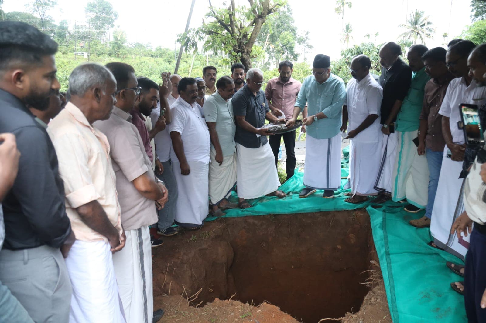 Panakkad Sayyid Munavvar Ali Shihab Thangal laying the foundation stone into the excavation pit